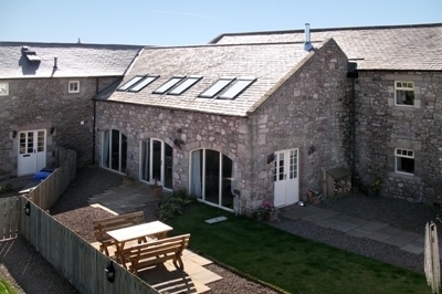 A stone house with a fence and picnic tables

AI-generated content may be incorrect.